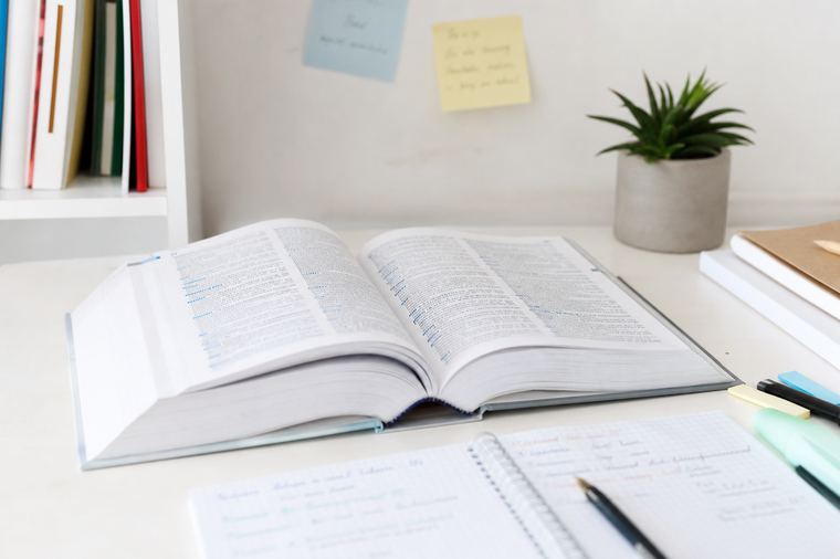 Libro appoggiato su un tavolo accanto a una tazza di tè fumante, pausa di lettura in segreteria