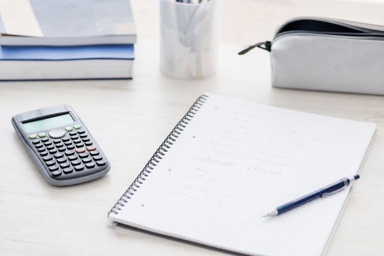 Postazione di lavoro con due schermi accesi, usata per calcolare i costi di un'ora di lezione.